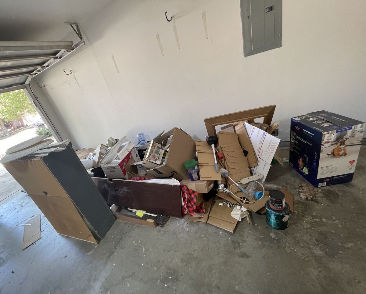 Cluttered garage full of boxes and old furniture before junk removal in San Antonio, TX